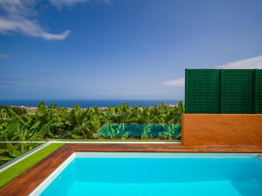 a swimming pool with a view of the ocean at Modern Banana Plantation House with sea views and private pool in Arucas
