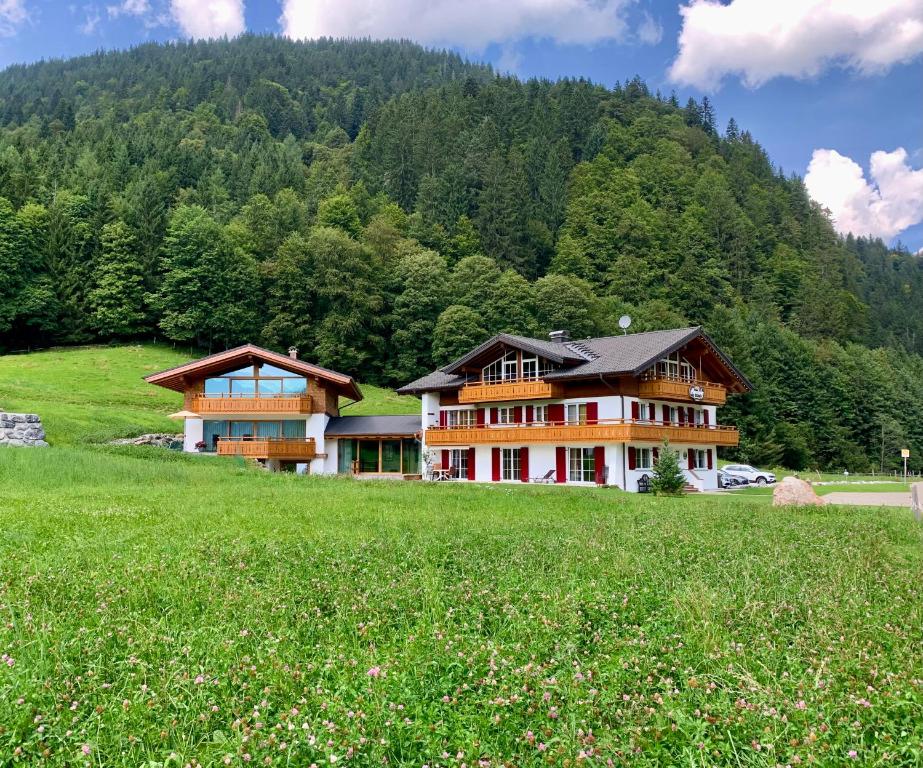 a large house on a hill with a green field at Alpenlodge Charivari - SommerBergBahn unlimited kostenlos in Oberstdorf