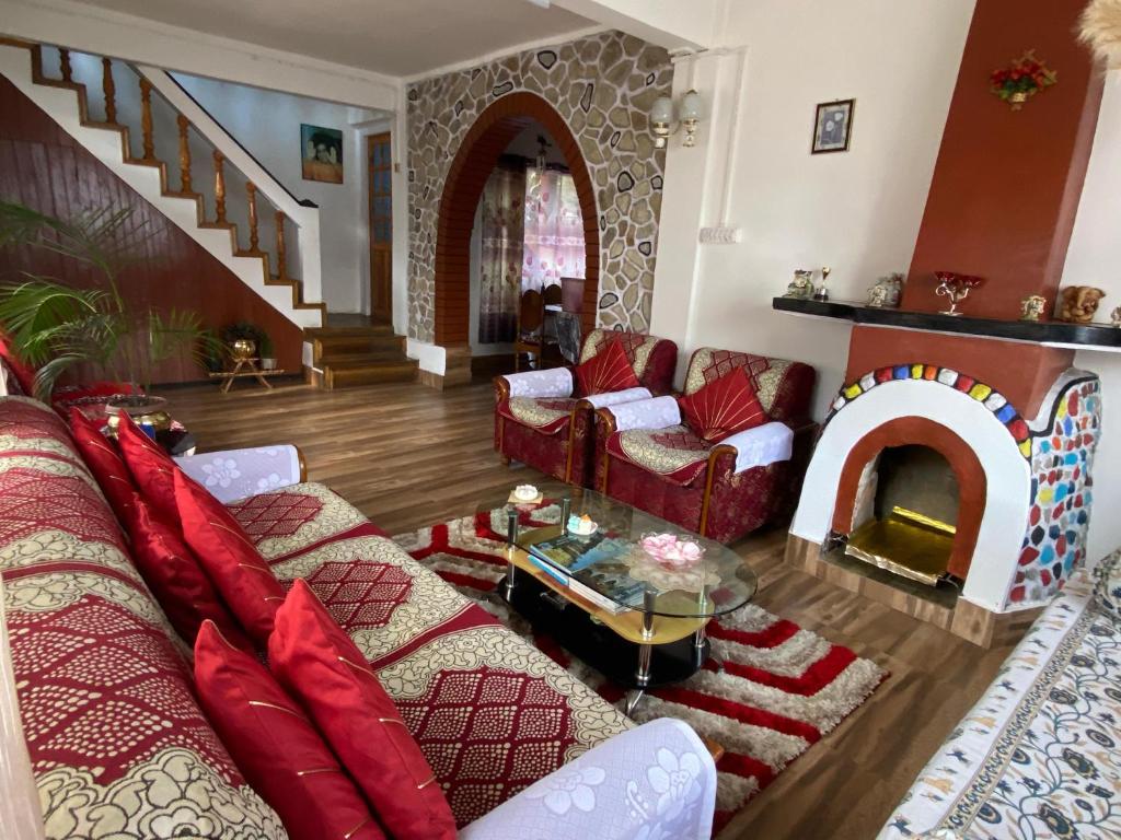 een woonkamer met een bank en een open haard bij Nimantrana Homestay in Darjeeling