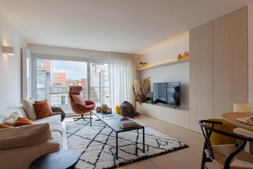 een woonkamer met een bank en een tafel bij Lovely 2 bedroom apartment in the heart of Knokke in Knokke-Heist