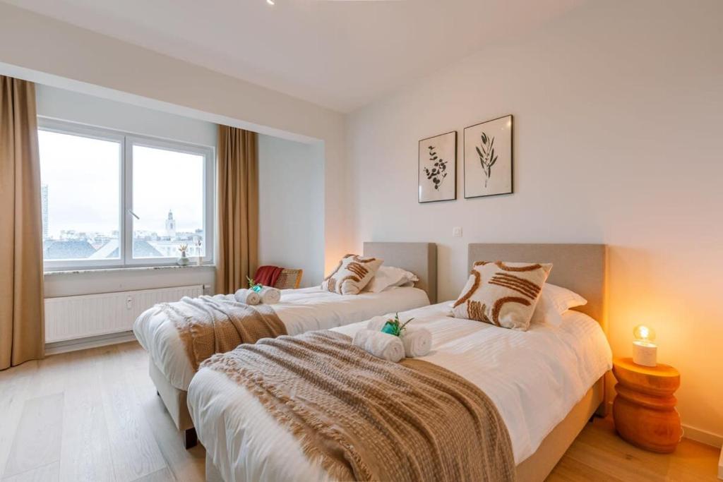 2 łóżka w pokoju hotelowym z oknem w obiekcie Bright family apartment with magnificent view w Ostendzie