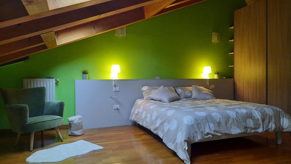een groene slaapkamer met een bed en een stoel bij ALLOGGIO IL TRULLO in Borso del Grappa