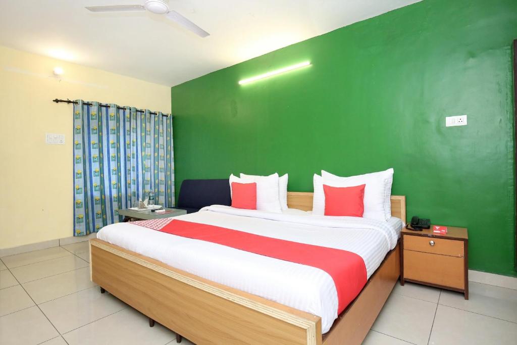 sypialnia z dużym łóżkiem i zieloną ścianą w obiekcie Hotel Rajmahal w mieście Dźalandhar