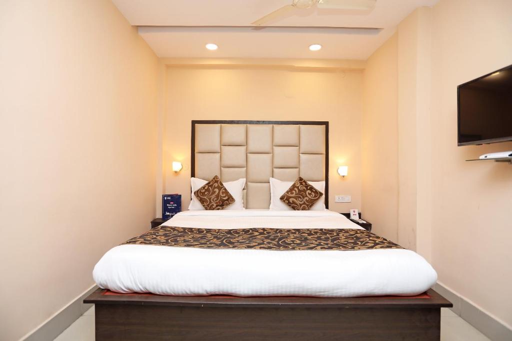 sypialnia z dużym łóżkiem i telewizorem z płaskim ekranem w obiekcie Collection O Hotel Greenpark w mieście Jamshedpur