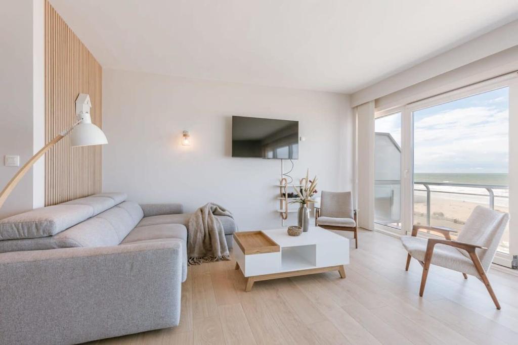 ein Wohnzimmer mit einem Sofa und einem Tisch in der Unterkunft Bright seaview apartment in Oostende in Ostende
