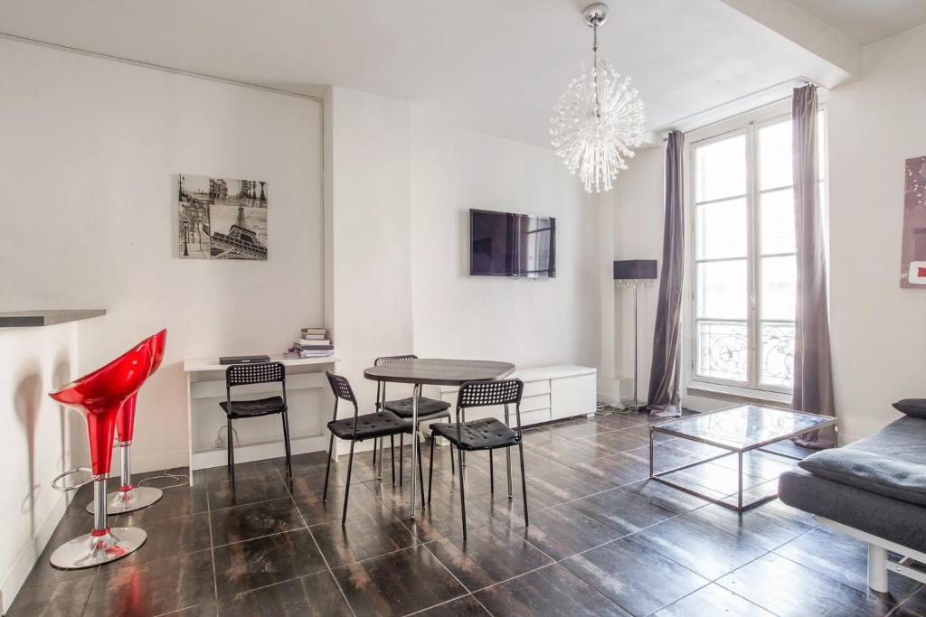 un salon avec une table, des chaises et un canapé dans l'établissement Paris St Germain Luxembourg, à Paris