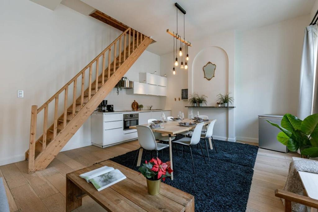 uma cozinha e sala de jantar com uma mesa e uma escada em Beautiful apartment on top location in Ghent em Gent