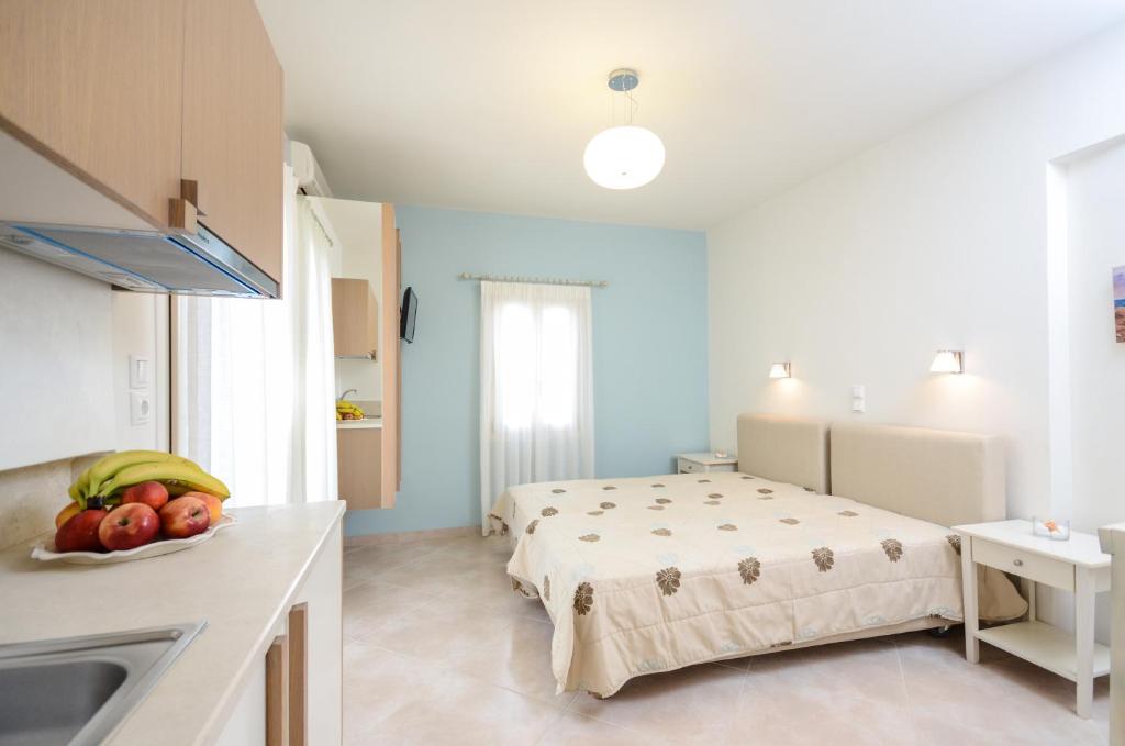a room with a bed and a kitchen with a sink at Irini Studios in Agia Anna Naxos