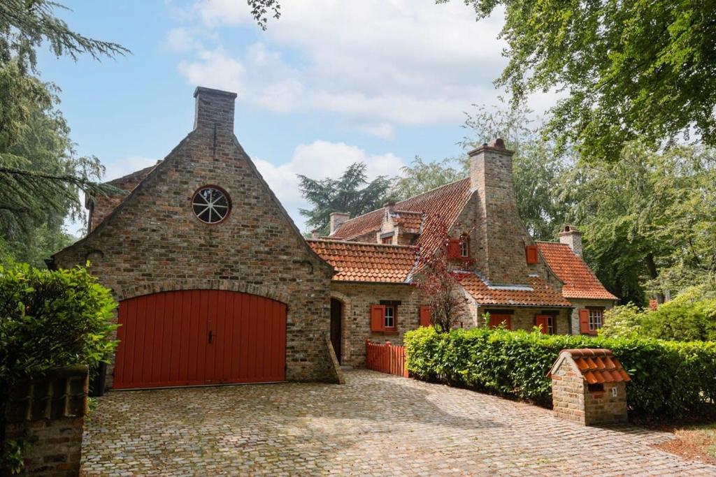 亞貝克的住宿－Authentic Villa 'Amore' located in nature near Bruges，一座大型砖屋,设有红色车库
