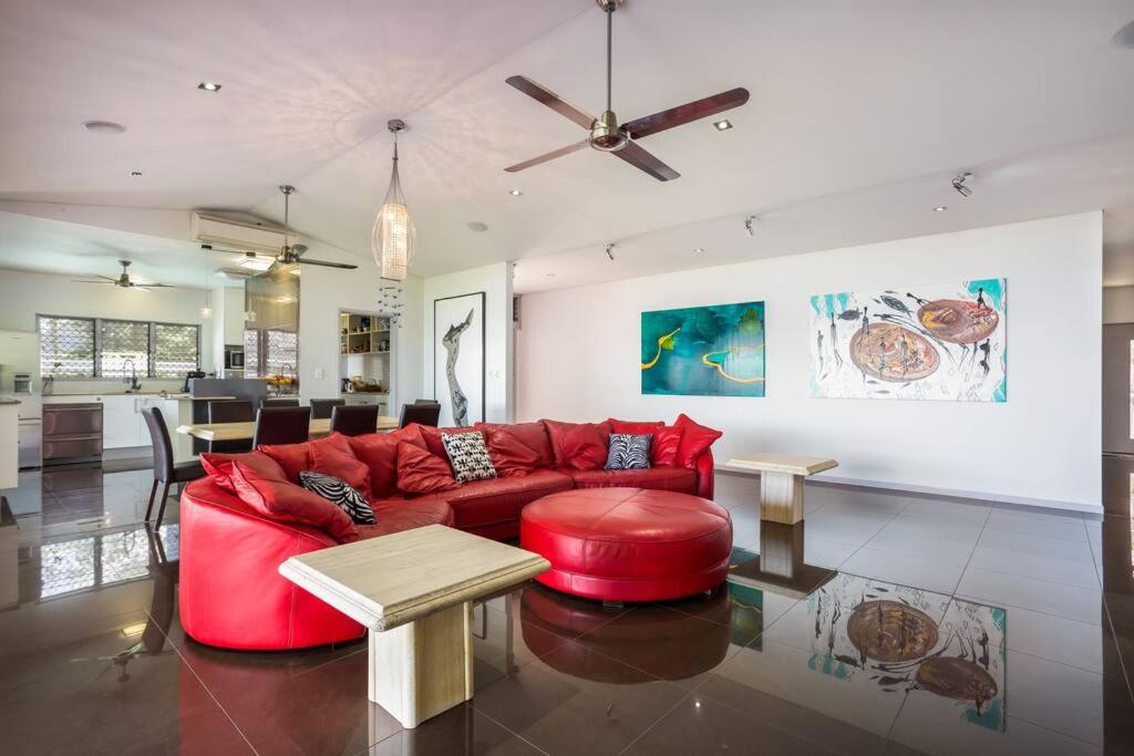 sala de estar con sofá rojo y mesa en On the very top of Cairns - Luxurious Entertainer, en Bayview Heights