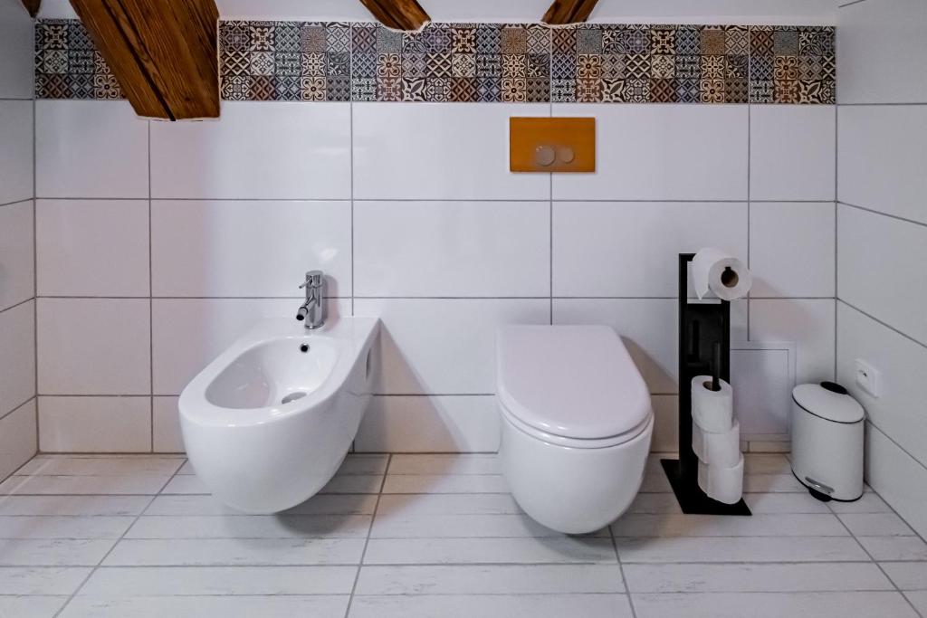 a white bathroom with a toilet and a bidet at Kníže Ferdinand Apartments in Mikulov