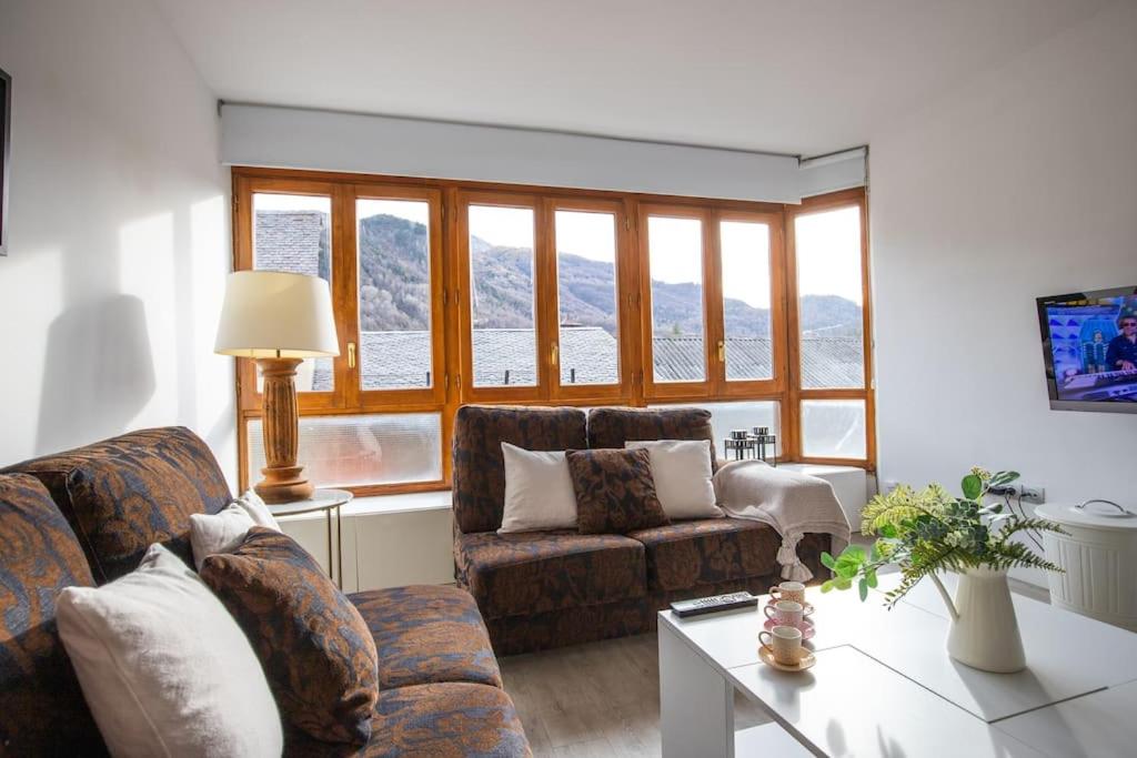 a living room with two couches and a table at Rural apartment in the mountains in Panticosa