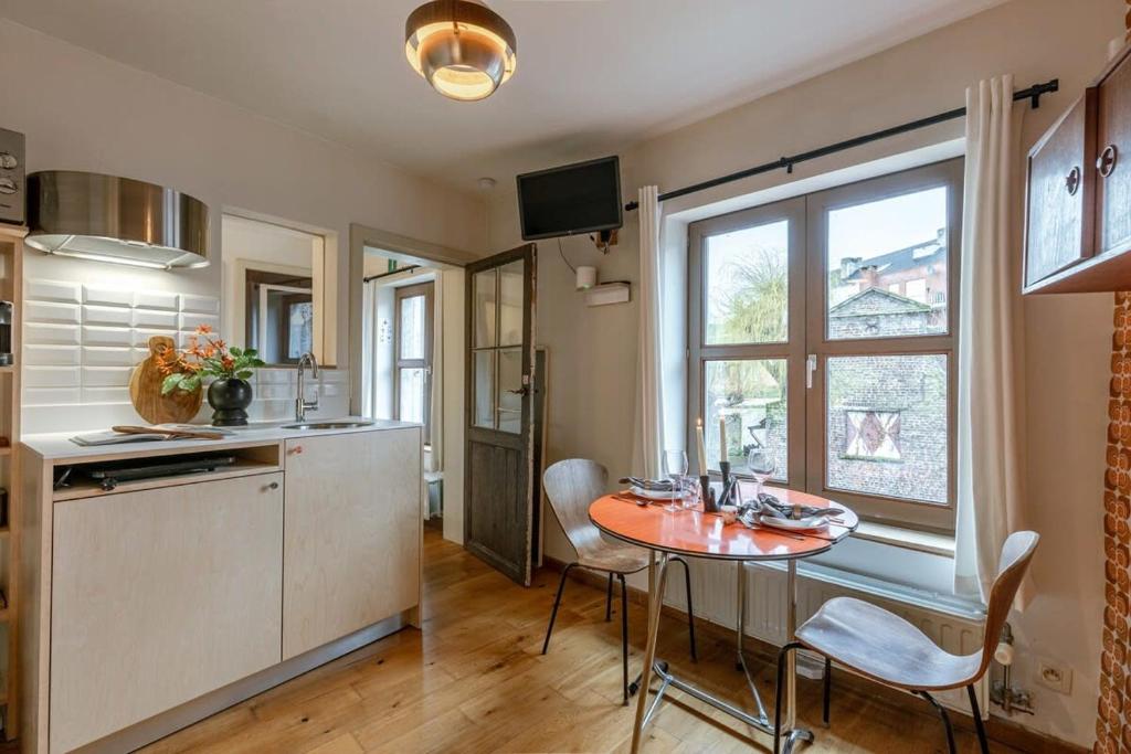 eine Küche mit einem Tisch und Stühlen sowie einem Fenster in der Unterkunft Characterful apartment for two in central Ghent in Gent