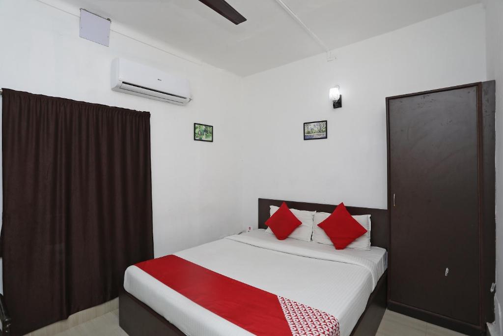 a bedroom with a bed with red pillows at OYO Jalan Lake View Near Mani Square in Tangra