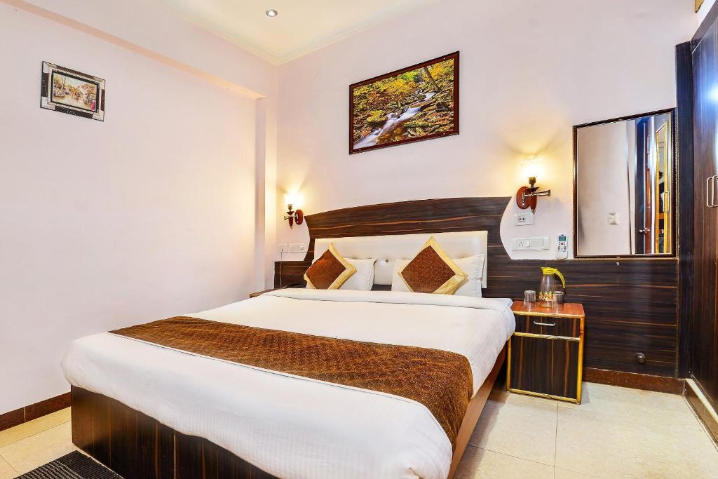 a bedroom with a large bed in a hotel room at Merit Hotel in Tājganj