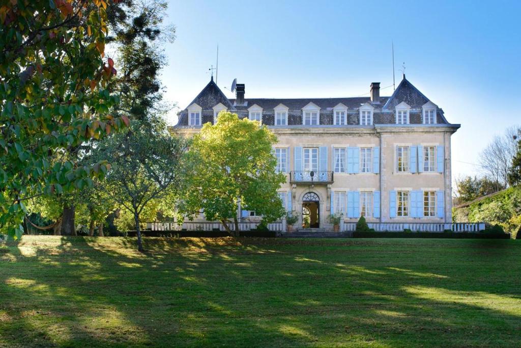 ein großes Haus mit großem Rasen davor in der Unterkunft Château Rieucazé in Rieucazé