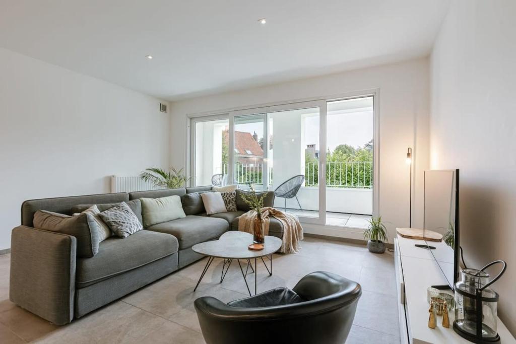 een woonkamer met een bank en een tafel bij Spacious apartment in Kortrijk in Kortrijk