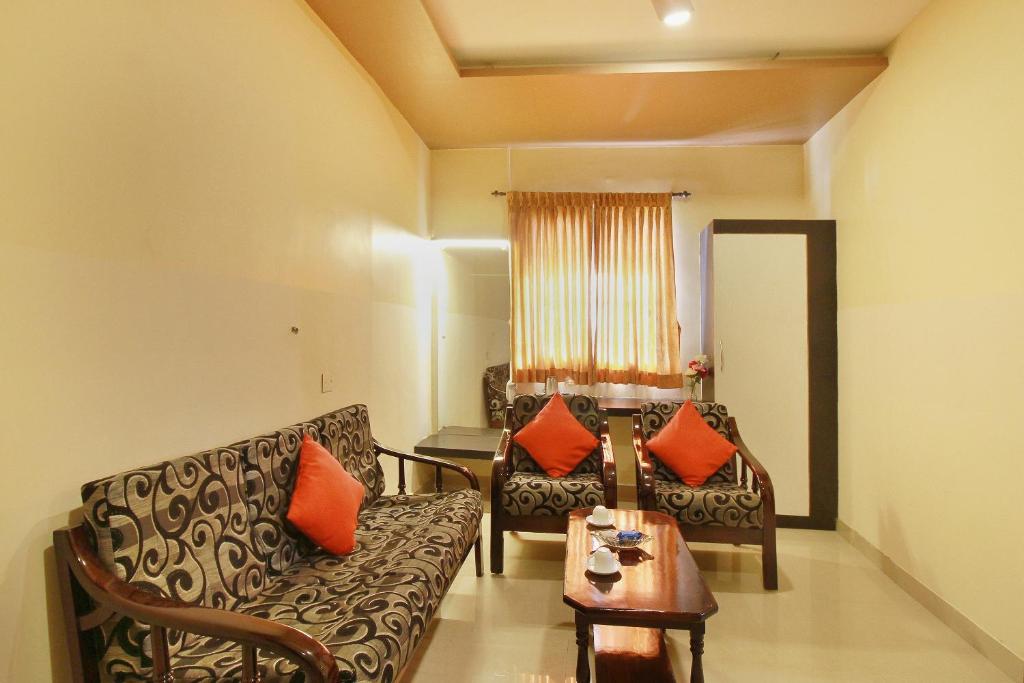 sala de estar con sofá y mesa en Hotel Rj Grand, en Coimbatore