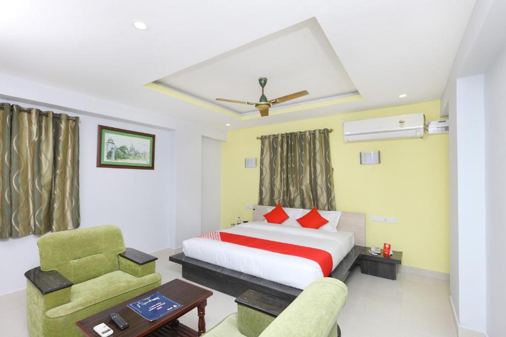 Hotel Sai Golden Rooms في تيروباتي: غرفه فندقيه بسرير وكرسي