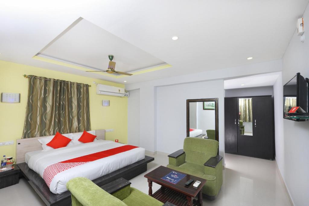 Habitación de hotel con cama y silla en Hotel Sai Golden Rooms, en Tirupati