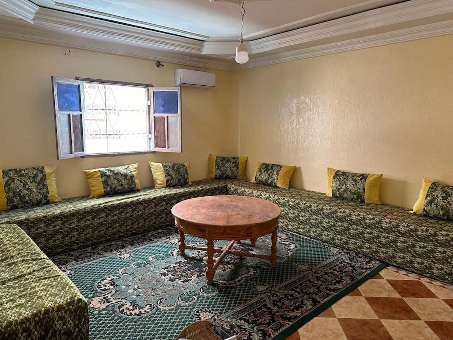 a living room with a couch and a table at Appartement à côté de l'aéroport in Marrakesh