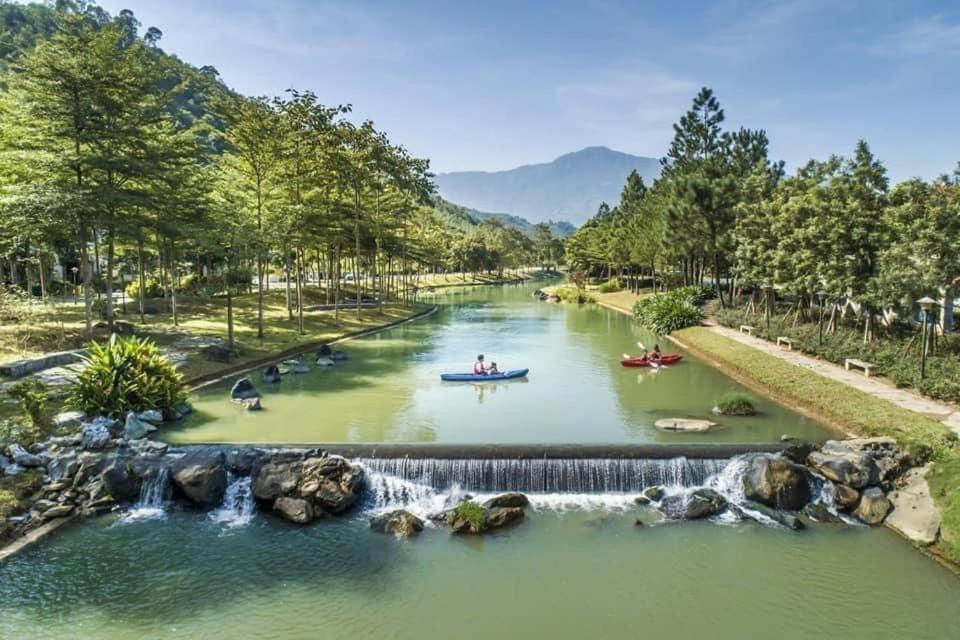 une rivière avec une cascade et des gens en bateau dans l'établissement Resort Xanh Villa 5 Stars, à Nam Giao