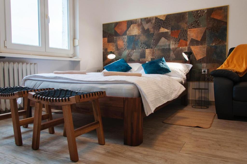 a bedroom with a large bed with blue pillows at Work & Stay Zagreb in Zagreb