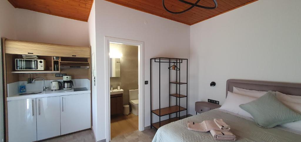 a bedroom with a bed and a kitchen with a microwave at Litochoro Appartment in Estate A2 in Litochoro