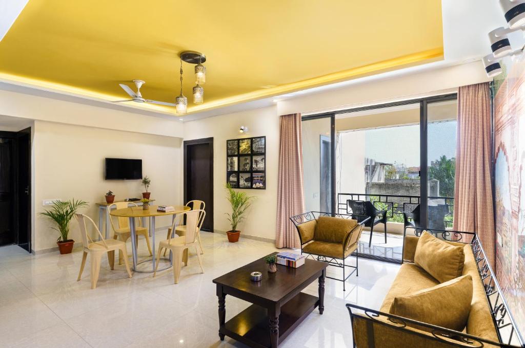 a living room with a yellow ceiling at Lazy Daze by UCH in Udaipur