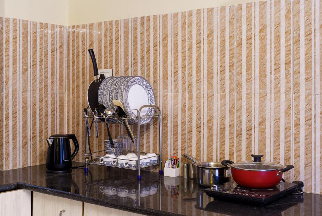 a kitchen counter with a mixer and a bowl on a counter at Lazy Daze by UCH in Udaipur