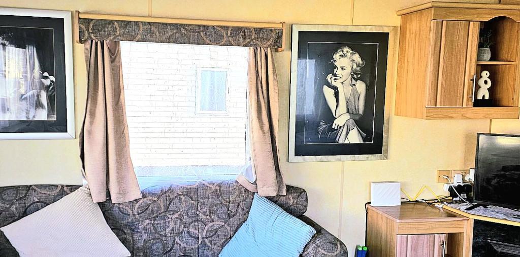 Habitación con ventana, sofá y TV. en J.R. Holiday Homes en Clacton-on-Sea