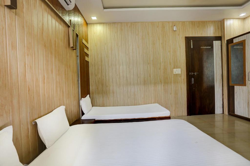 - une chambre avec 2 lits et une porte dans l'établissement MAHADEV GUEST HOUSE, à Kokkíni Khánion