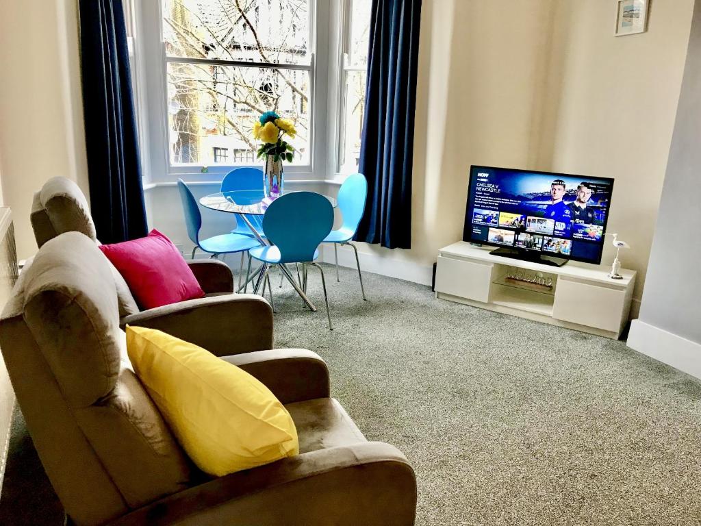 a living room with a couch and a television at Coastal Apartment in Southend-on-Sea