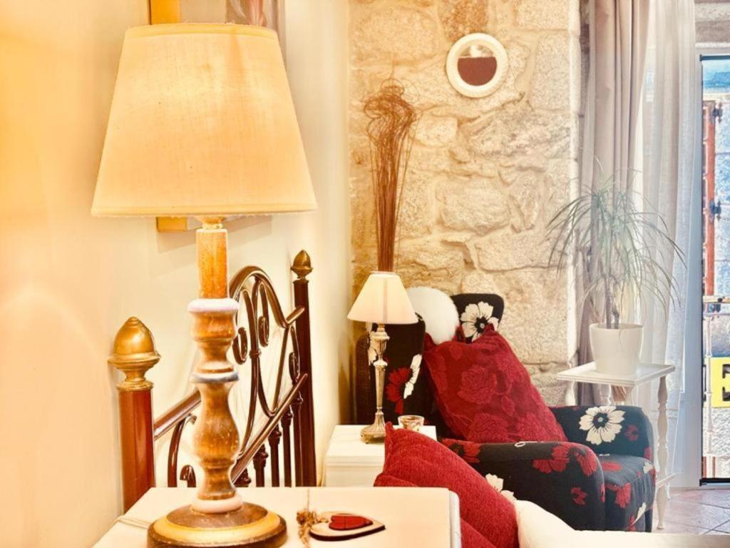 sala de estar con lámpara y sofá en Holibai, Vermello, Un rincón con encanto cerca de la playa, en Baiona