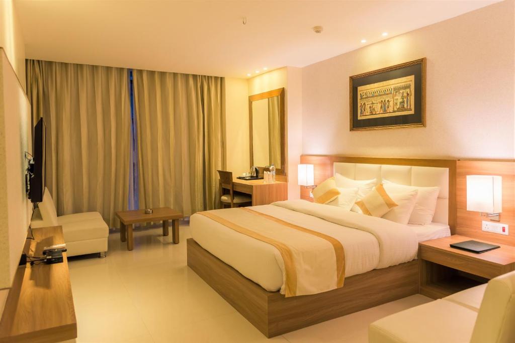 a hotel room with a large bed and a desk at Sangai Continental (The Boutique Hotel) in Imphal