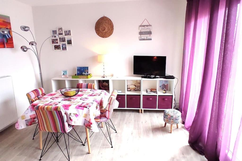 une salle à manger avec une table et une télévision dans l'établissement Ty Loca Loca Proche mer et centre-ville Parking privatif, à Concarneau