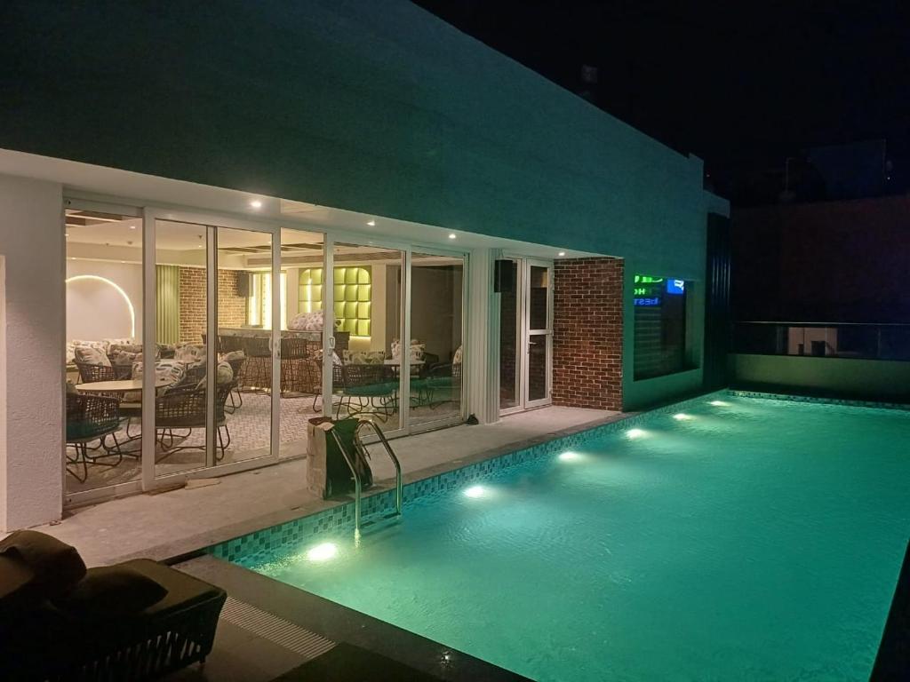 阿姆利則的住宿－Regenta Place Amritsar by Royal Orchid Hotels Limited，一座带灯光的大型游泳池