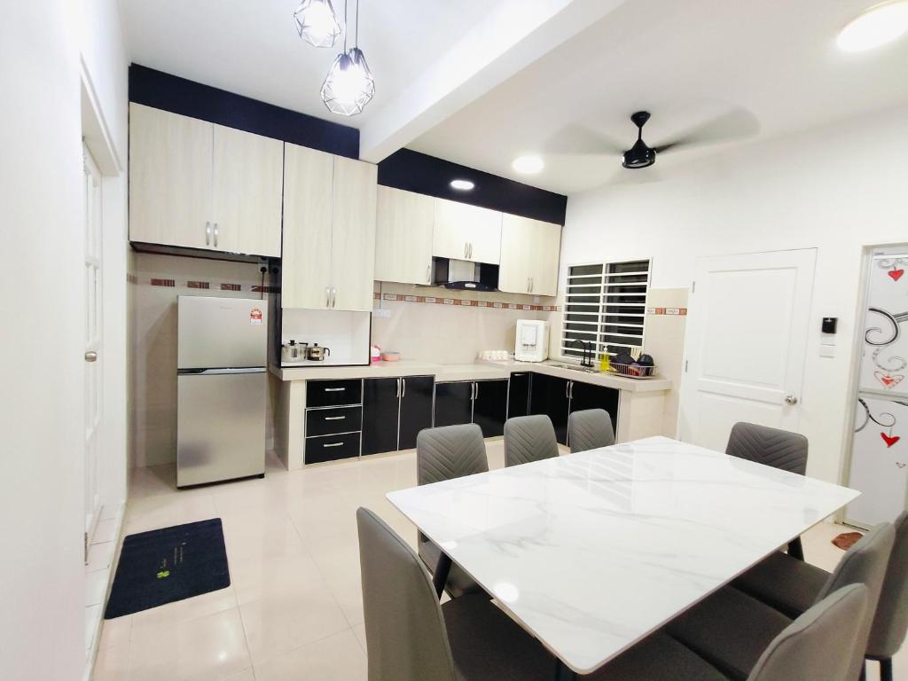 a kitchen with a white table and chairs in it at 98 Homestay Sandakan in Sandakan