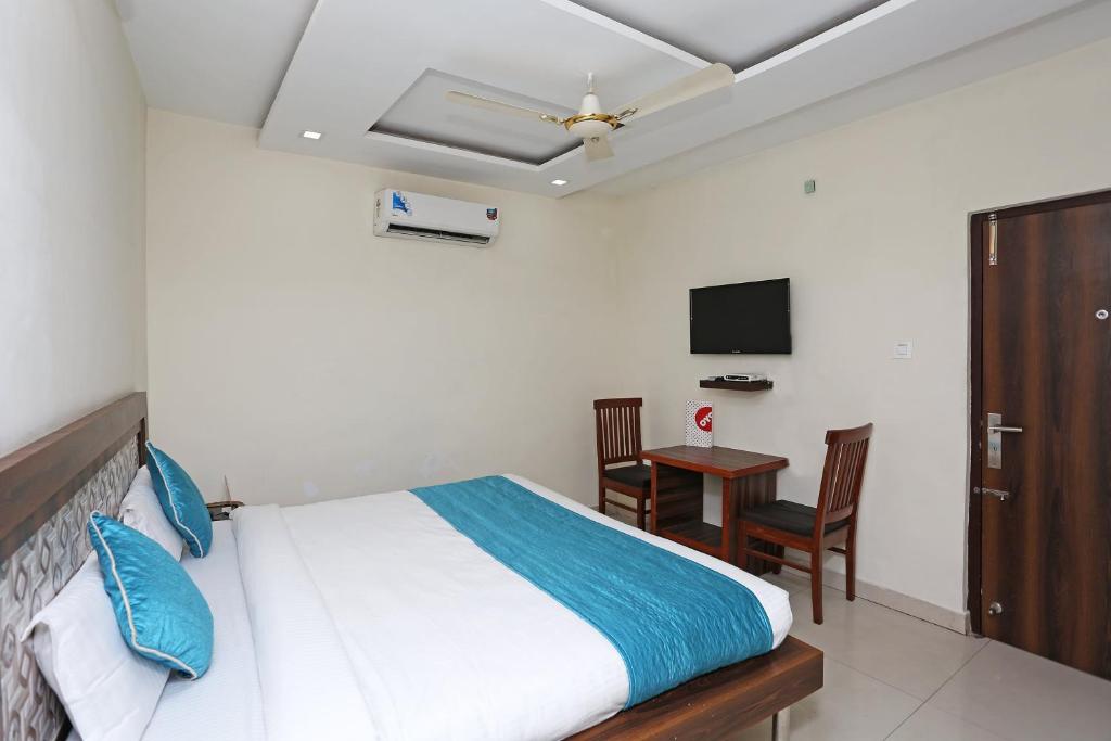 a bedroom with a bed and a desk and a television at Hotel Sea in Patiāla