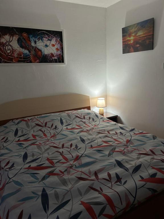 a bedroom with a bed with a colorful comforter at Apartments Jankovic in Podgorica