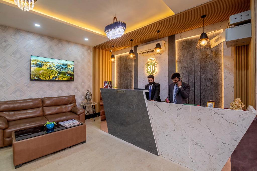 two men standing at a bar in a lobby at Shree Jee Hotel - NIT Faridabad in Faridabad