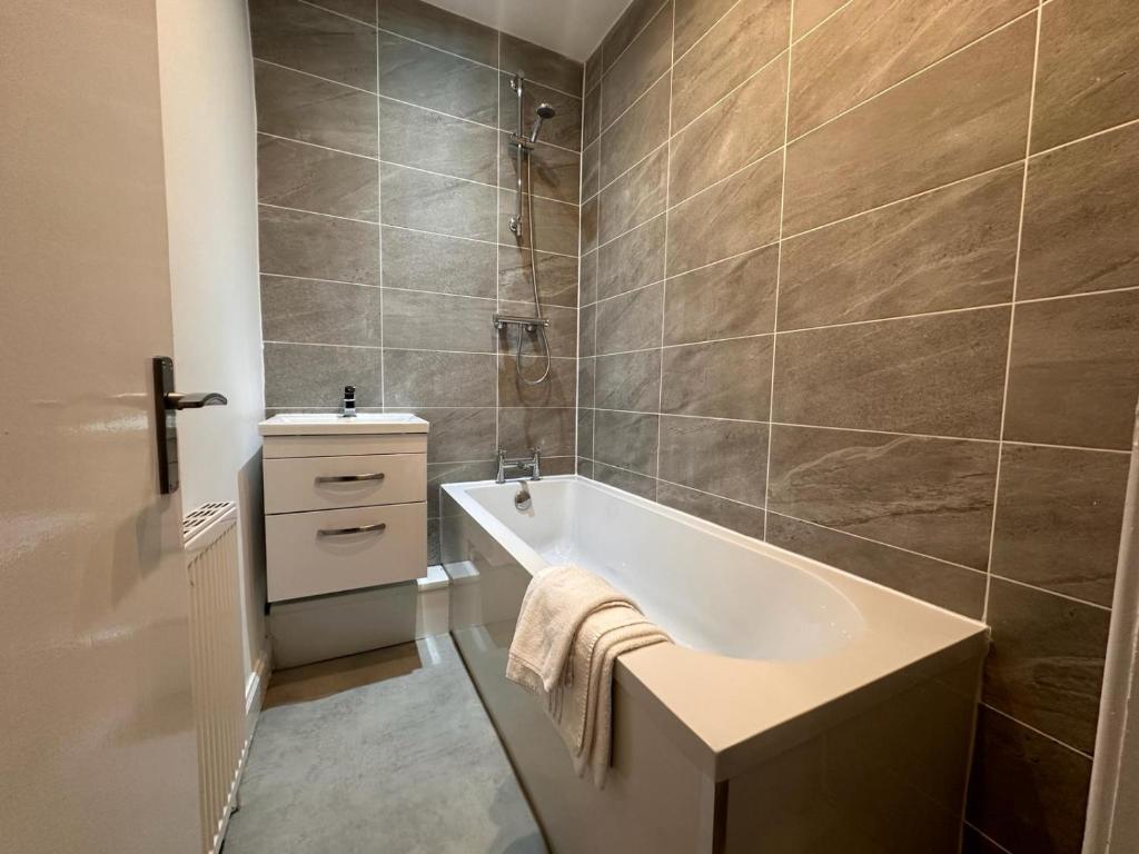 a bathroom with a tub and a sink at Partick Apartment in Glasgow