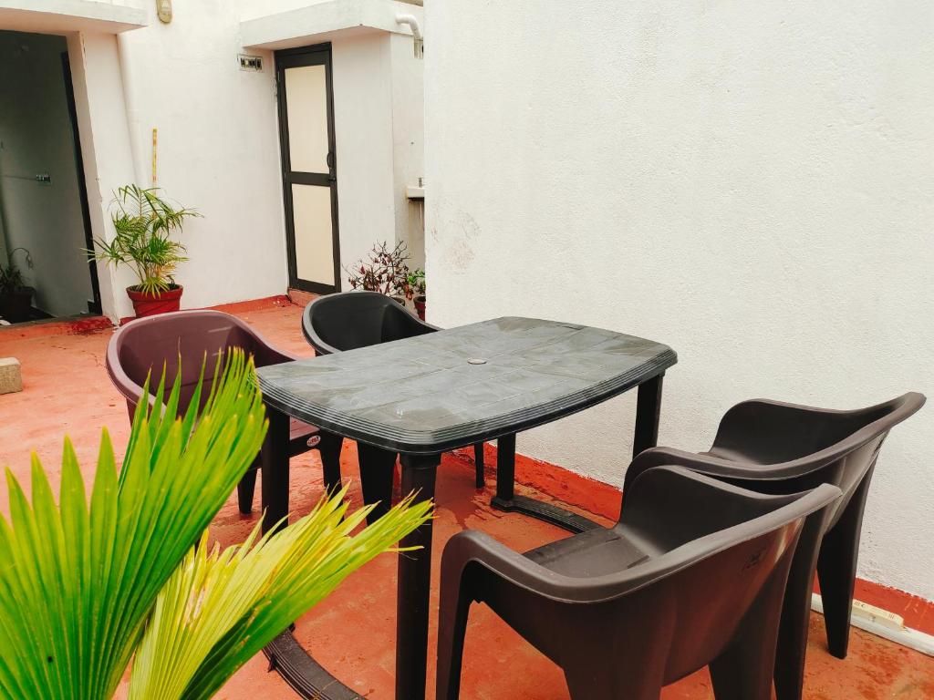 uma mesa e cadeiras num pátio com plantas em Dreamy Residency em Pondicherry