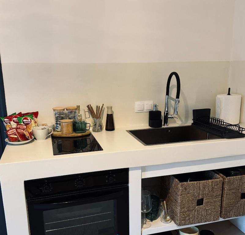 a kitchen counter with a sink and a stove at Vie rêvée luxury suites in Ganema