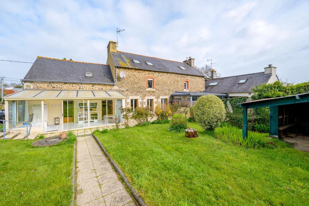 una vista exterior de una casa con patio en La Maison des Vacances - Maison avec grand jardin, en Lantic