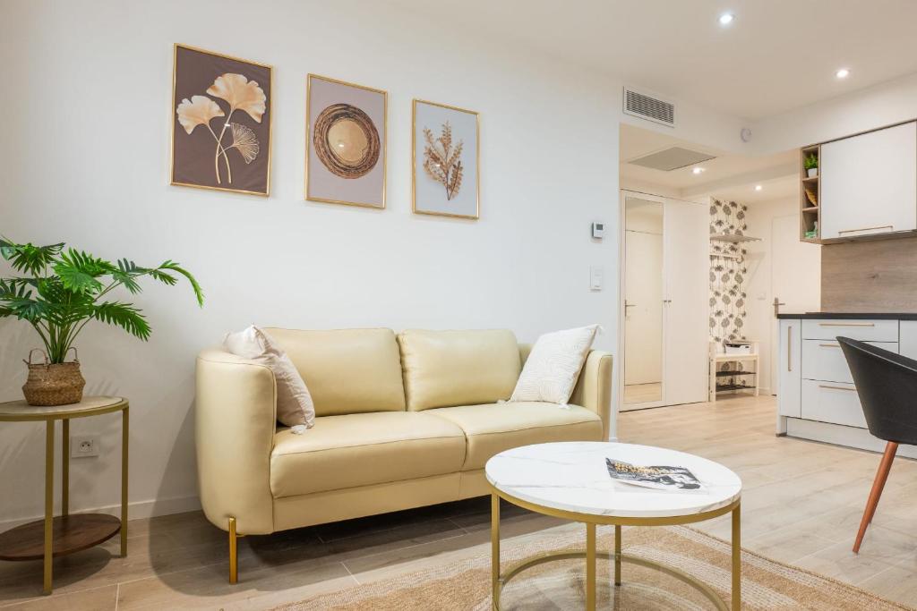 un salon avec un canapé et une table dans l'établissement Upscale 3-room apartment 300m from the beaches, à Cannes
