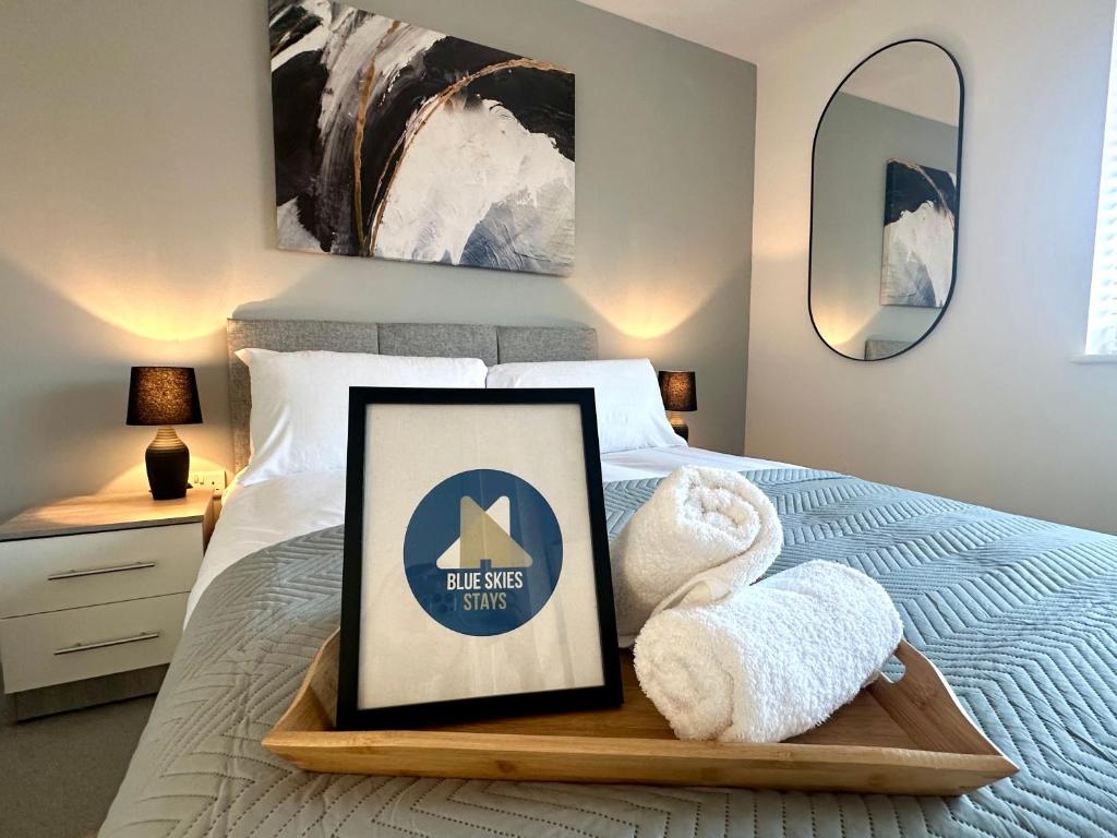 a bed with a wooden tray with towels on it at Apartment 1 - The Railway Apartment Building by Blue Skies Stays in Darlington