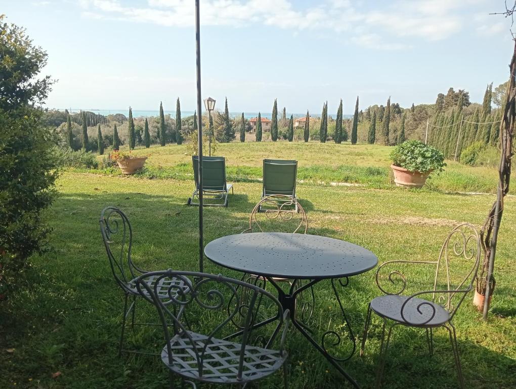 una mesa y sillas sentadas en el césped en Agriturismo Podere Gianmaria, en Castiglioncello