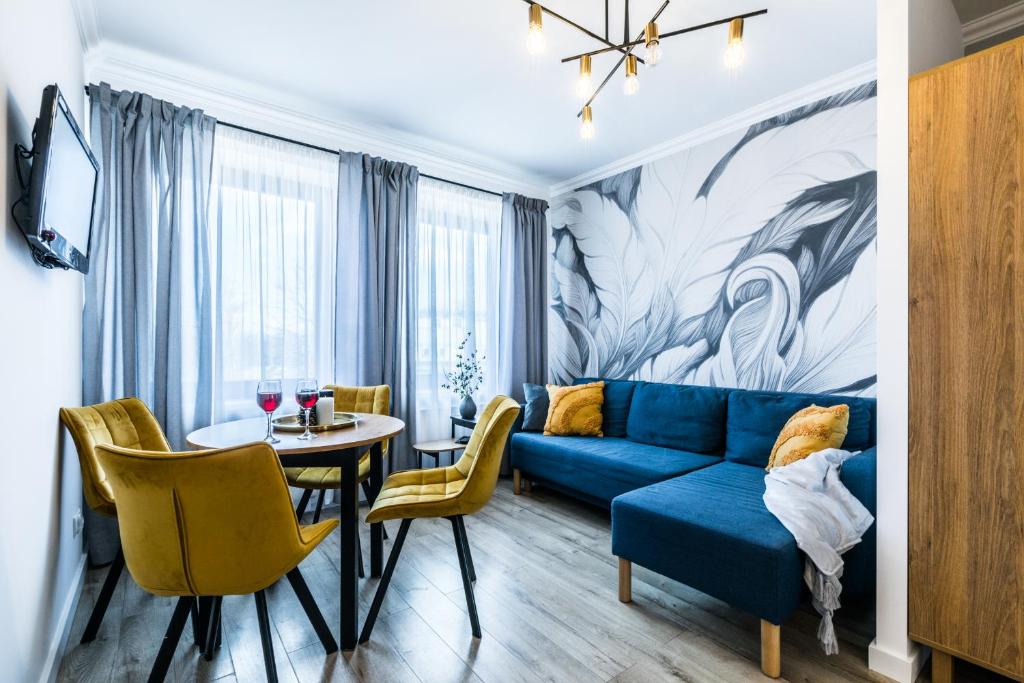 Apartamenty Krupówki 48B في زاكوباني: غرفة معيشة مع أريكة زرقاء وطاولة