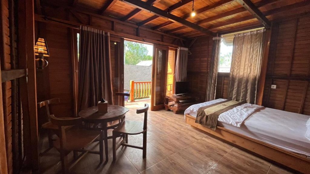 sypialnia z łóżkiem i stołem w pokoju w obiekcie Villa & Home Stay Kubu Alit Besakih w mieście Besakih